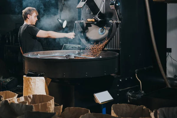 Mann steuert Prozess der Kaffeebohnen-Röstung in traditioneller Maschine — Stockfoto