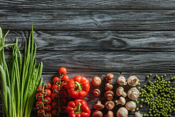 Top view of various raw vegetables on wooden tabletop — Stock Photo