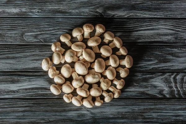 Vista dall'alto dei funghi champignon a forma di cerchio sulla superficie di legno — Foto stock