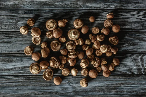 Vista superior da pilha de cogumelos champignon marrom cru na superfície de madeira — Fotografia de Stock