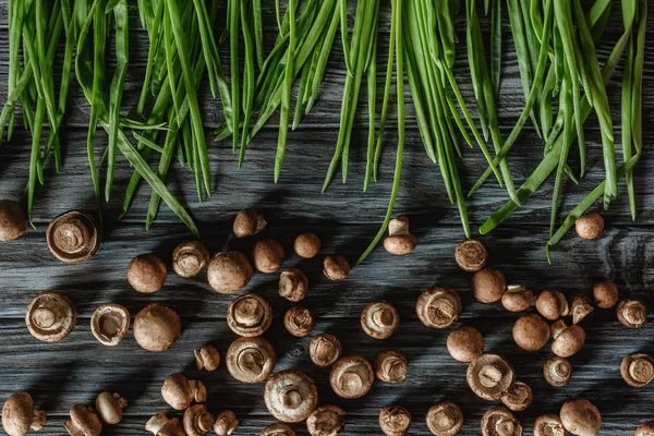 Vista dall'alto dei funghi champignon con porri su un tavolo di legno — Foto stock