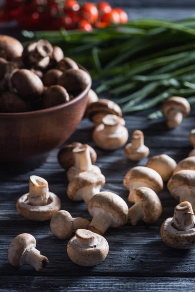 Primer plano de deliciosos champiñones crudos con puerro en mesa de madera oscura - foto de stock