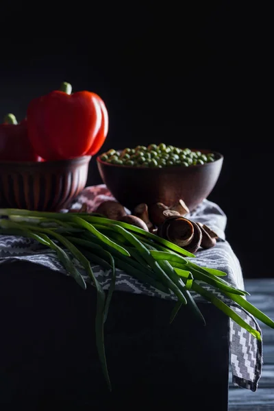 Cogumelos de champignon crus com várias verduras no guardanapo azul no preto — Fotografia de Stock