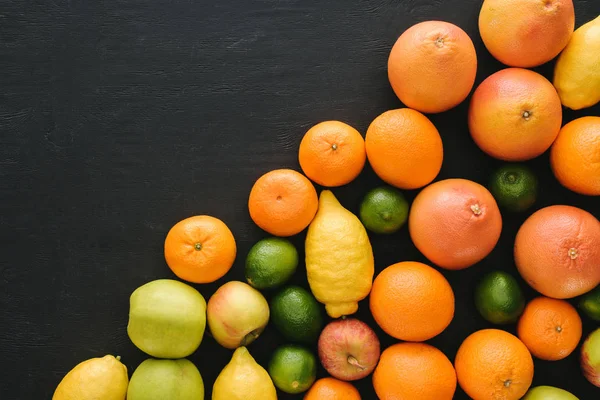 Vue de dessus de divers fruits mûrs sur la surface noire — Photo de stock