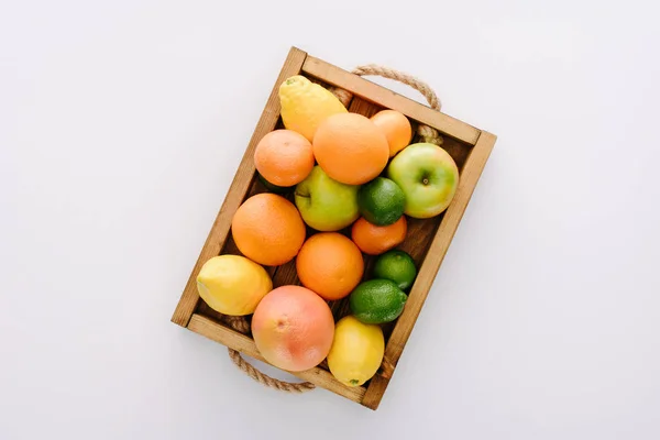 Top view of various ripe fruits in wooden box on white tabletop — Stock Photo