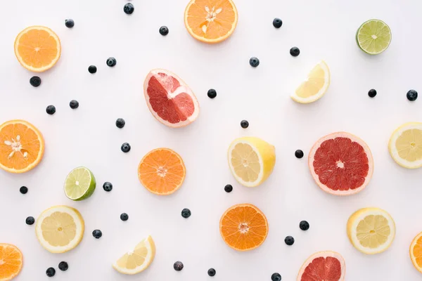 Top view of citrus fruits slices and blueberries on white surface — Stock Photo