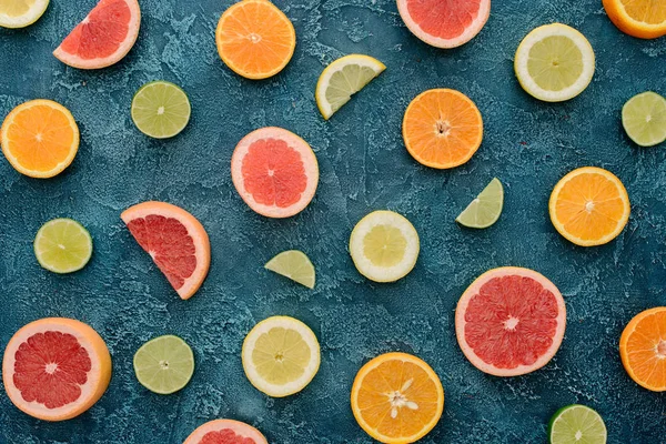 Vista superior de frutas cítricas maduras fatias na superfície de concreto azul — Fotografia de Stock