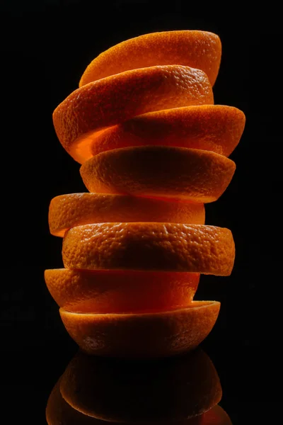 Primer plano de rodajas apiladas de naranja fresca aisladas en negro - foto de stock