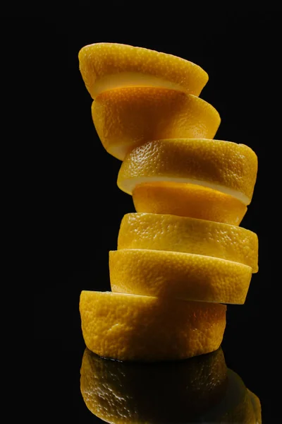Primer plano de rodajas apiladas de limón aislado en negro - foto de stock