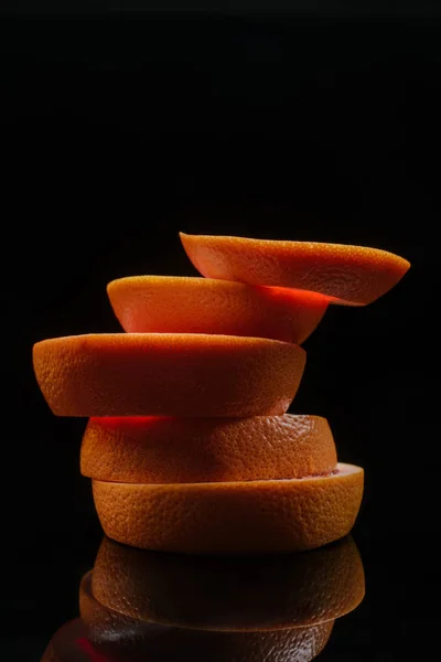Primer plano de rodajas apiladas de naranja aisladas en negro - foto de stock