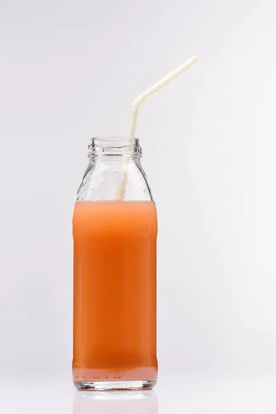 Botella de vidrio de zumo de pomelo fresco en blanco - foto de stock