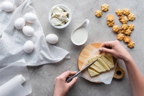 Tiro cortado de mulher cortando manteiga na tábua de corte para torta caseira em mesa cinza — Fotografia de Stock