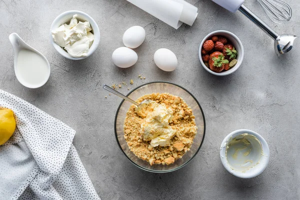 Top view of arranged dough for pie, strawberries, raw chicken eggs and baking paper on grey tabletop — Stock Photo