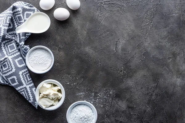 Posa piatta con disposizione degli ingredienti per torta fatta in casa sulla superficie grigio scuro — Foto stock