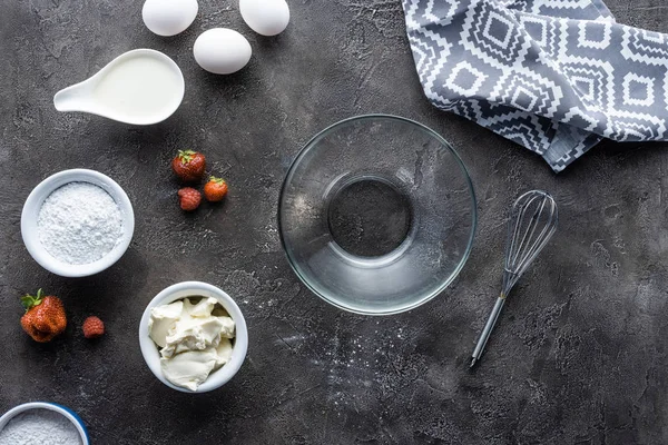 Plat avec disposition des ingrédients pour tarte maison et bol vide sur la surface gris foncé — Photo de stock
