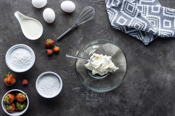 Tendido plano con arreglo de ingredientes para pastel casero en la superficie gris oscuro - foto de stock