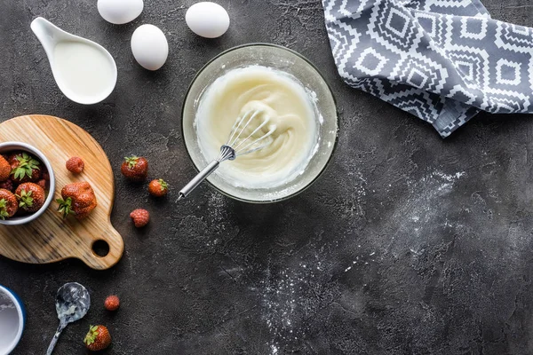 Posa piatta con disposizione degli ingredienti per torta fatta in casa sulla superficie grigio scuro — Foto stock