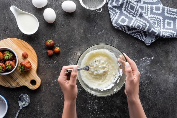 Abgeschnittene Aufnahme einer Frau, die Creme für hausgemachten Kuchen auf dunkelgrauer Tischplatte herstellt — Stockfoto