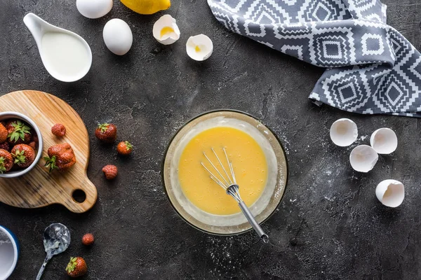 Vue de dessus de la fabrication de la crème pour le processus de tarte et les ingrédients disposés sur la surface gris foncé — Photo de stock