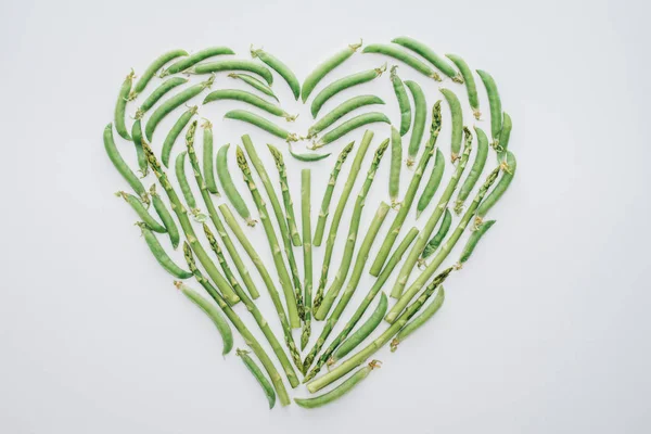 Top view of heart made of fresh green peas and asparagus isolated on white — Stock Photo