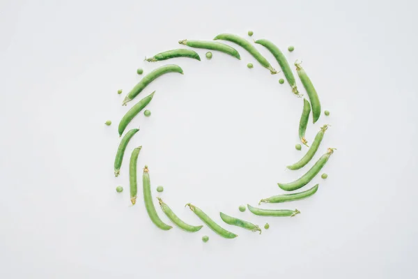 Top view of round frame made of fresh green peas isolated on white background — Stock Photo