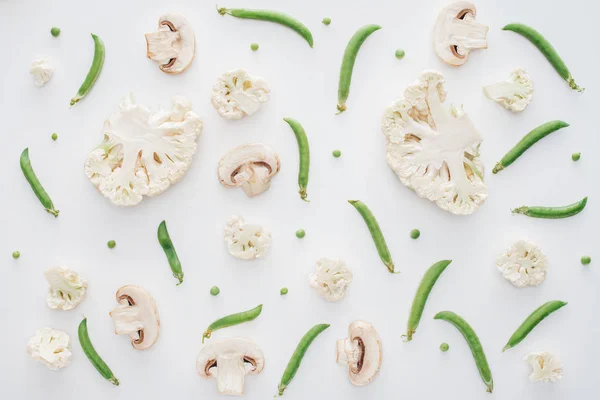 Vue de dessus du chou-fleur, des champignons et des petits pois frais tranchés isolés sur fond blanc — Photo de stock