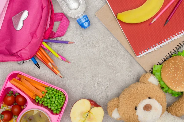 Вид зверху лоток з дітьми обід для школи, сумка з олівцями та блокнотами на мармуровому столі — стокове фото