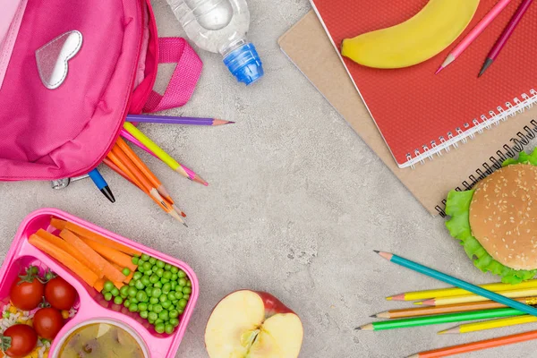 Top view of tray with kids lunch for school, notebooks and pencils on marble table — Stock Photo