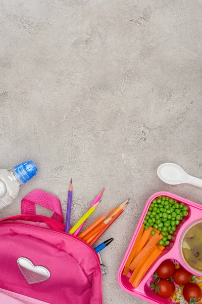 Vista superior de la bandeja con almuerzo para niños para la escuela, bolsa con lápices en la mesa de mármol - foto de stock