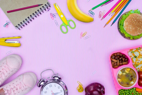 Top view of tray with kids lunch for school, alarm clock and shoes on violet surface — Stock Photo