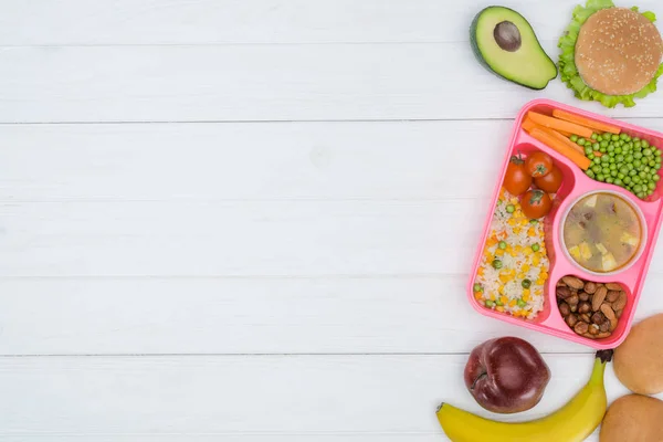 Vue du dessus du plateau avec enfants déjeuner pour l'école et fruits sur table en bois — Photo de stock