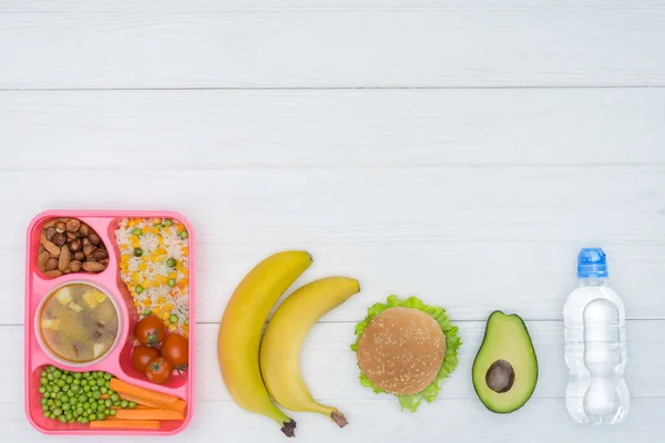 Vista superior de la fila de niños almuerzo para la escuela en la mesa blanca — Stock Photo