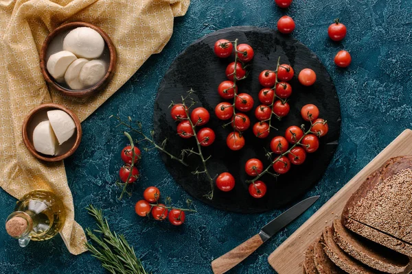 Ingredients for sandwiches with tomatoes and mozzarella on dark blue table — Stock Photo