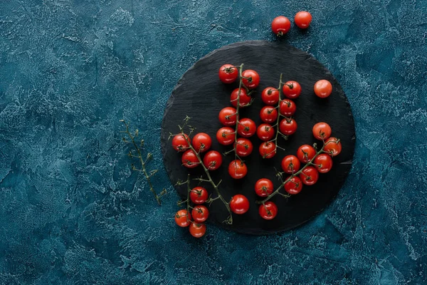 Tomates cereja maduros vermelhos em placa de ardósia escura — Fotografia de Stock