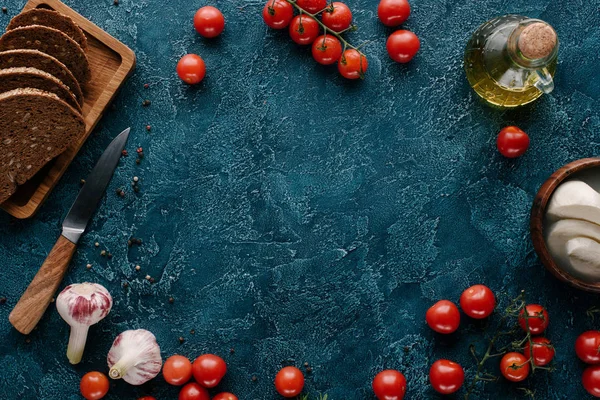 Ripe red tomatoes with bread and spices on dark blue table — Stock Photo