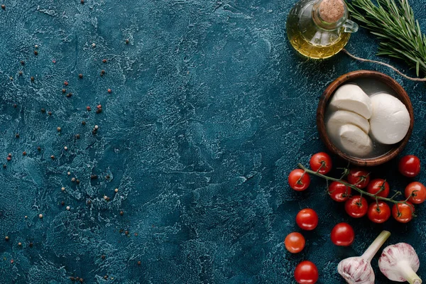 Fromage mozzarella aux tomates et condiments sur table bleu foncé — Photo de stock