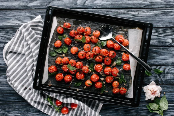 Plat à pâtisserie avec tomates cerises rouges sur table en bois sombre — Photo de stock