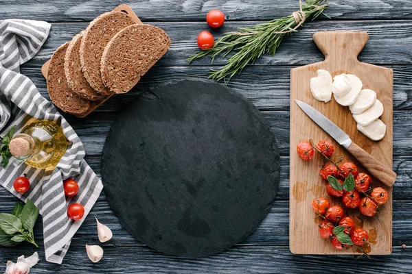 Ingredients for sandwiches with cheese and tomatoes on dark wooden table — Stock Photo