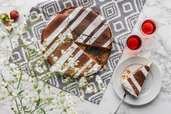 Vista dall'alto di deliziosa torta fatta in casa, fragole fresche e fiori bianchi — Foto stock