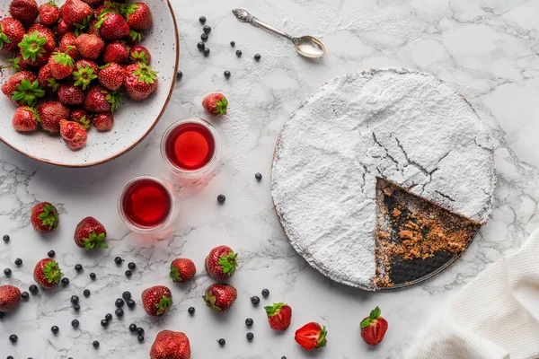 Vue de dessus de délicieux gâteau fait maison avec glaçage et baies fraîches sur la surface du marbre — Photo de stock