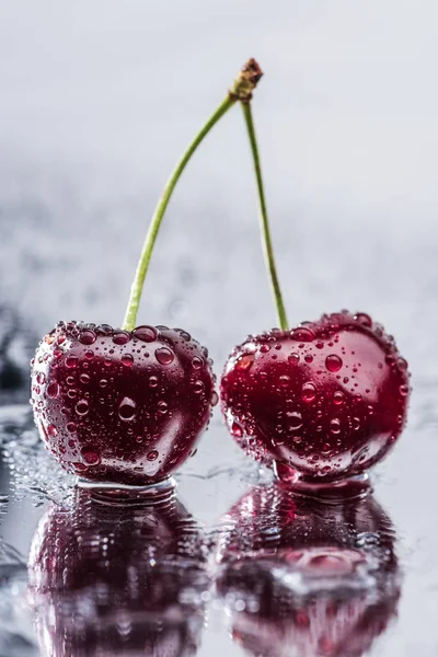 Close up view of red ripe cherries with water drops on wet surface — Stock Photo