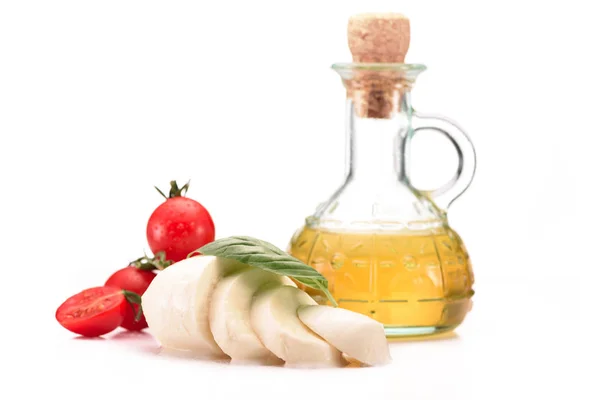 Close up view of arranged glass bottle with oil, cherry tomatoes and mozzarella cheese with basil leaves isolated on white — Stock Photo