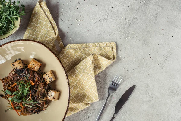 Food composition with soba with tofu and vegetables decorated with germinated seeds of sunflower on grey tabletop — Stock Photo