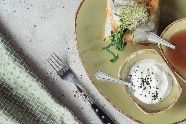 Ansicht von Samosas in Phyllo-Teig gefüllt mit Spinat und Paneer dekoriert mit gekeimten Samen von Luzerne und Sonnenblume serviert auf Teller auf grauer Tischplatte — Stockfoto