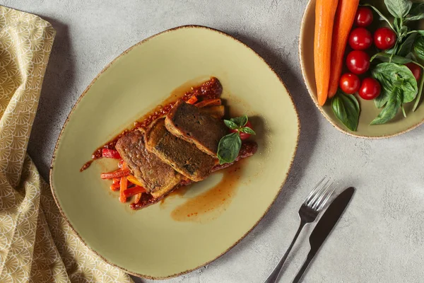 Tendido plano con verduras frescas, paneer en nori algas sobre juliana vegetal, ropa de cama y cubiertos sobre la mesa gris - foto de stock