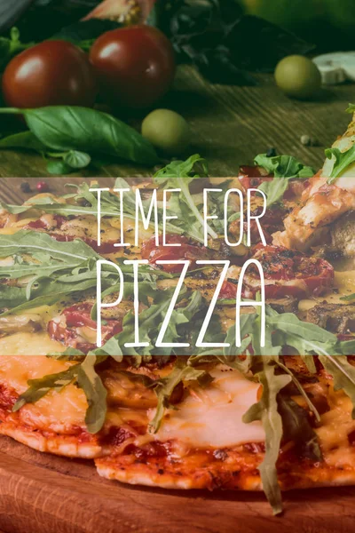 Закрытие нарезанной горячей итальянской пиццы со свежей рукколой, время для надписи на пицце — стоковое фото