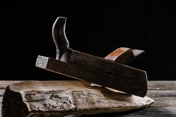 Close up view of vintage woodworker plane and stump isolated on black — Stock Photo