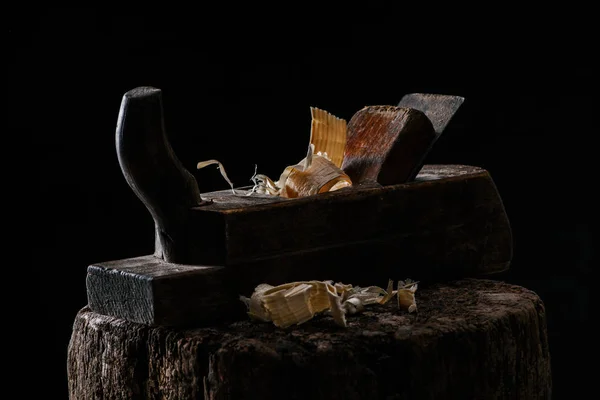 Close up view of vintage woodworker plane on wooden stump isolated on black — Stock Photo