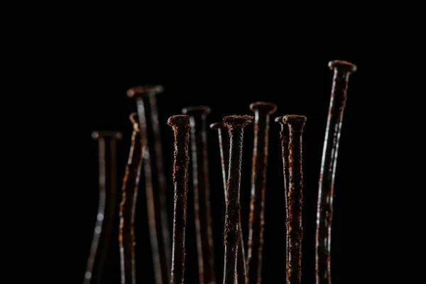 Vista de cerca de la vendimia uñas oxidadas aisladas en negro - foto de stock