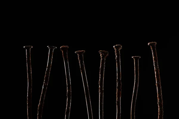 Закрыть вид винтажных ржавых ногтей, изолированных на черном — стоковое фото